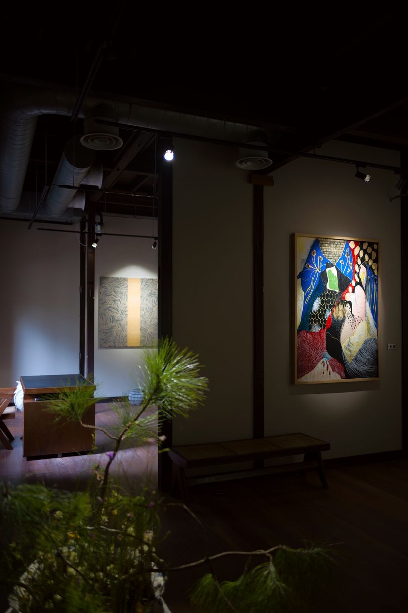 A pine arrangement in the foreground, with Richard Long&rsquo;s mud work and Naotaka Hiro&rsquo;s painting on the walls beyond.